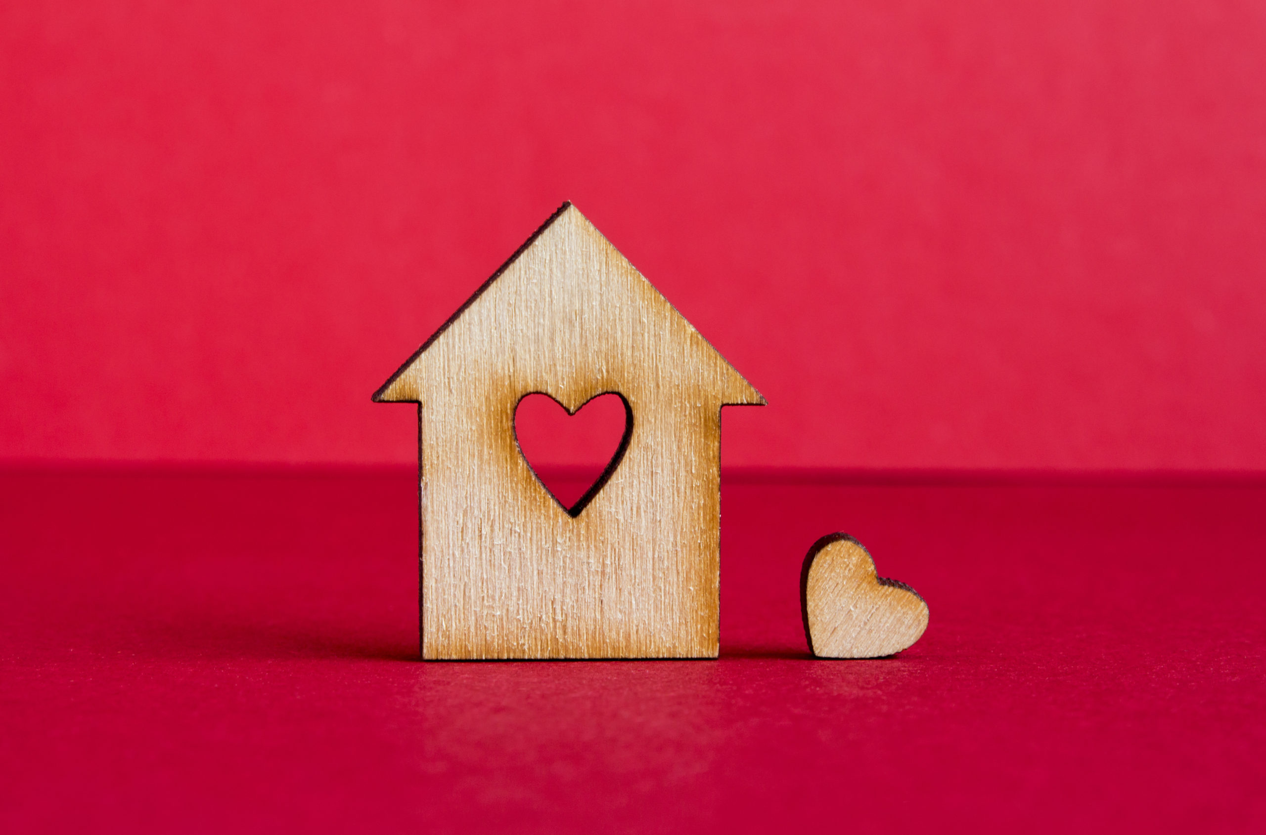 Wooden house with hole in the form of heart with little heart on